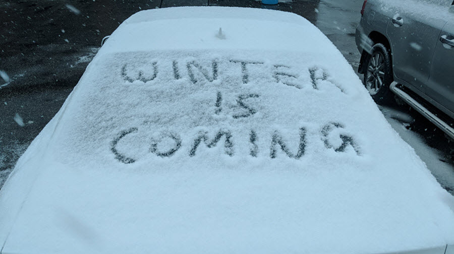 winter is coming written in snow on a car